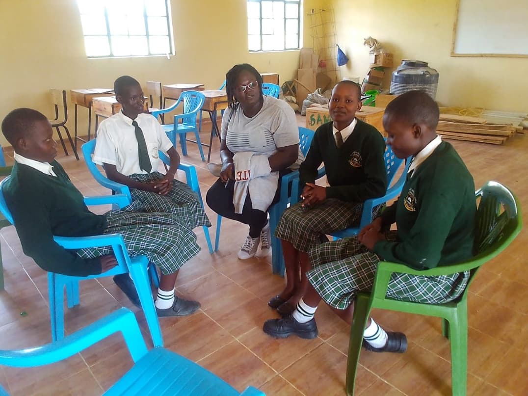 CESUD mentor facilitating an interactive circle session with schoolgirls in their classroom